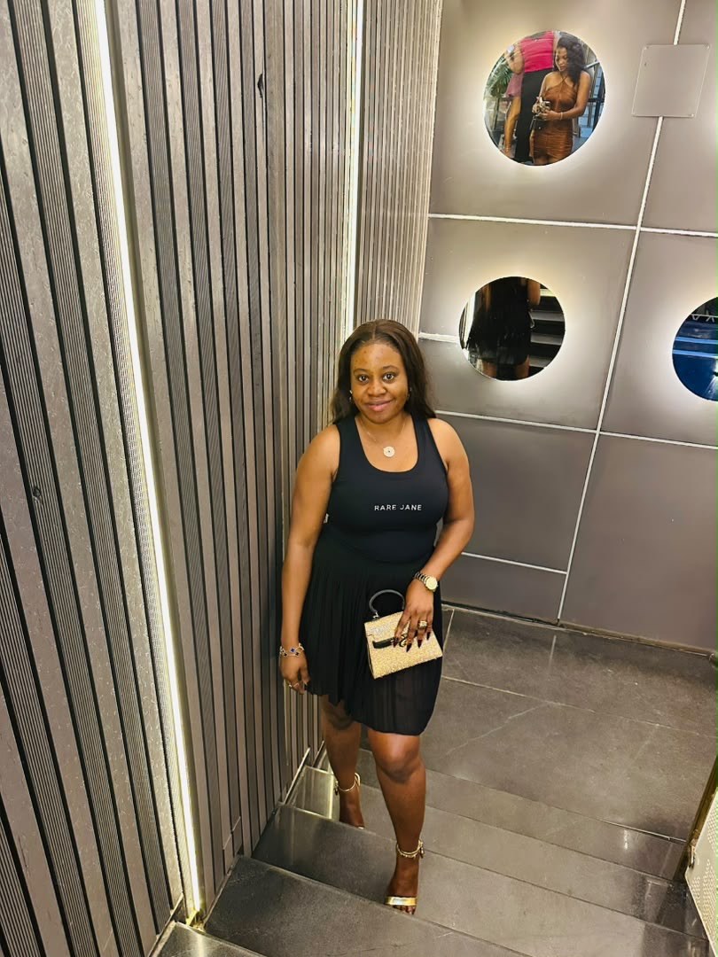 Rare Jane customer Janet wearing the Essence Tank Top in black with a pleated skirt
